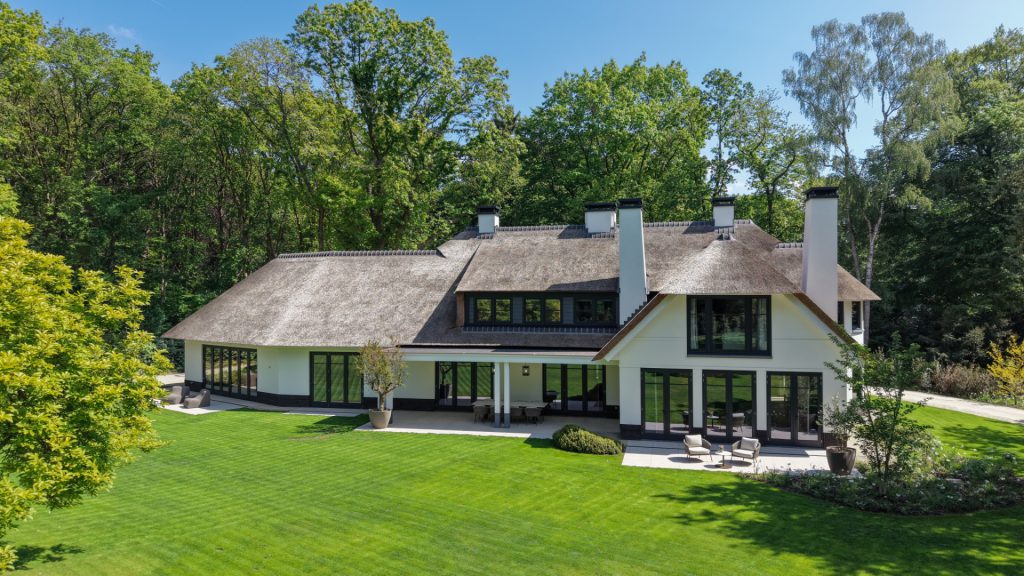 Villa met rieten dak in een groene tuin in Blaricum