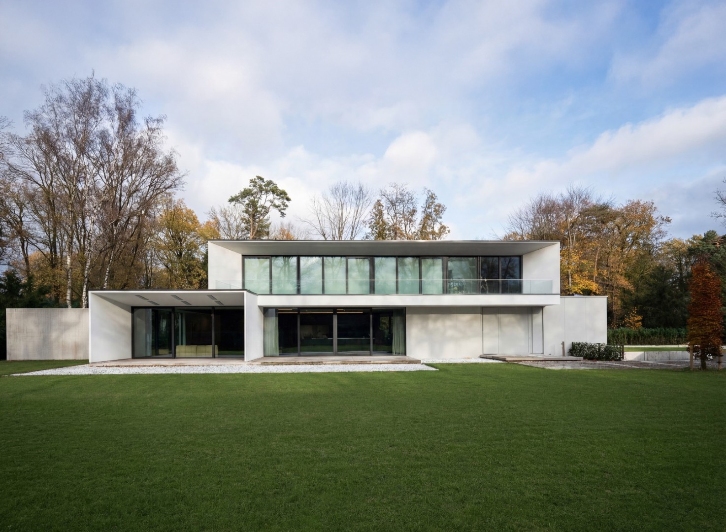 Moderne villa met gazon en bomen